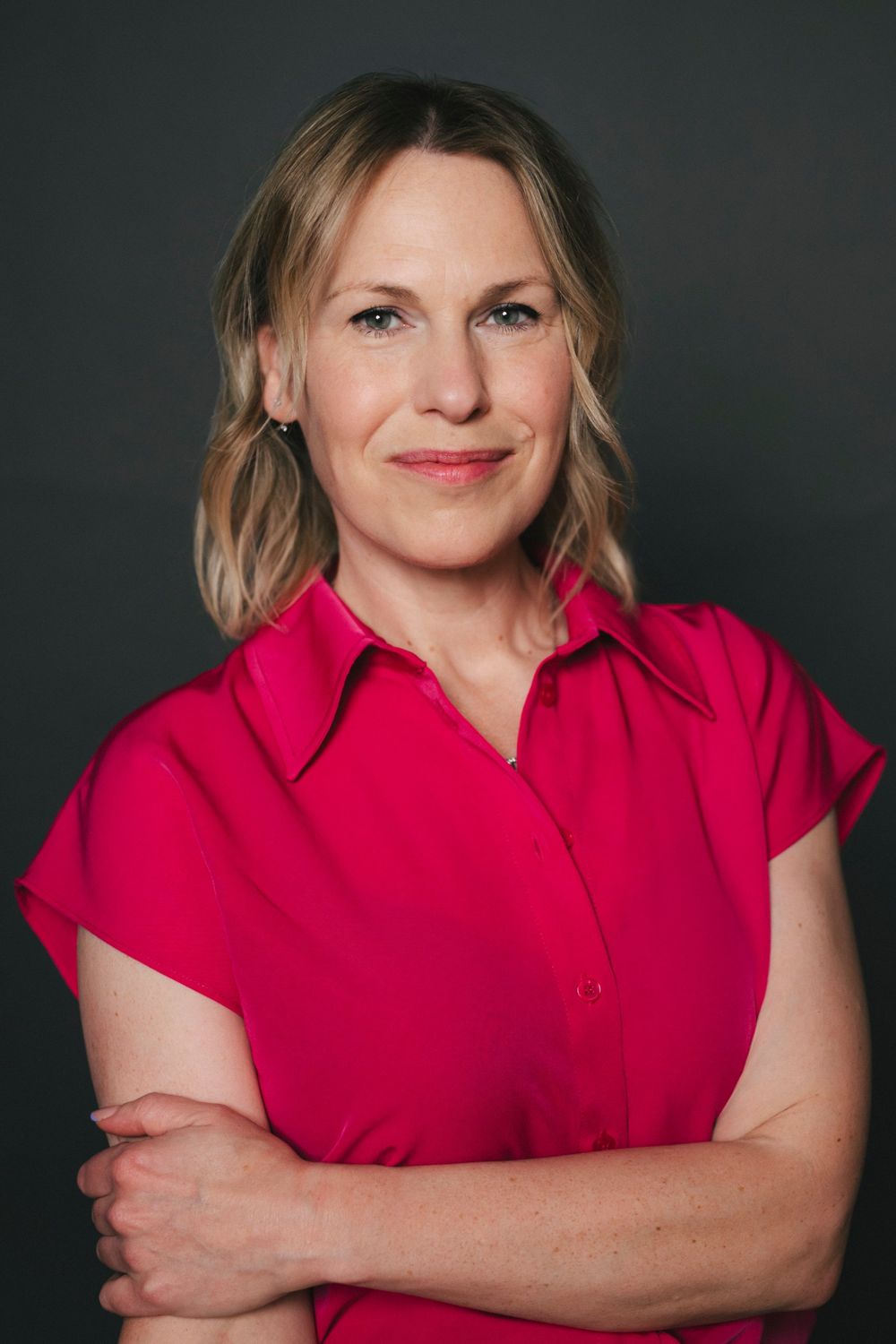Kate Maddison-Greenwell, founder of People Efficient, in a pink shirt with arms folded, smiling